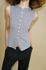 Top tipo chaleco confeccionado en hilatura con viscosa, con diseño de rayas horizontales en blanco y azul marino. Presenta cuello redondo, manga sisa y cierre frontal con botones.
