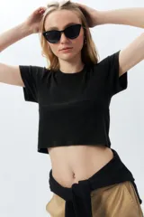 Top corto negro ajustado al cuerpo, de manga corta y cuello redondo.