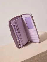 Billetera de poliuretano texturizado color rosado con cierre perimetral y logo metálico al frente.