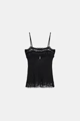 Top de tirantes finos confeccionado en tejido semitransparente, con escote recto decorado con encaje a tono, bordados florales y detalles de terciopelo con lazos. Presenta un diseño con abertura frontal y bajo con encaje.