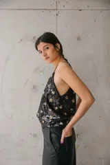 Blusa de tirantes finos confeccionada en lentejuelas negras con estampado de estrellas doradas.
