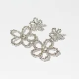 Aros colgantes plateados con forma de flor y detalle de strass. Cierre con tuerca a presión.