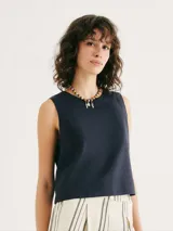Blusa sin mangas de corte recto y holgado, con cuello redondo y diseño minimalista en color verde.
