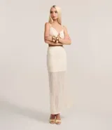 Pollera de largo new midi confeccionada en tejido de punto con aplicación de lentejuelas en toda la prenda. Presenta un diseño ajustado al cuerpo, forro interno y cintura elástica.