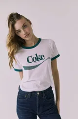Remera de manga corta estilo ringer, color blanca con ribetes verde oscuro en cuello y puños. Cuenta con estampado frontal de Coca-Cola en color verde.