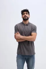 Remera polo verde militar de algodón pima, con cuello y puños acanalados, cierre frontal de tres botones y pequeño bordado de ave en el pecho.