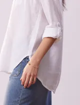 Blusa color beige de lino, marca Dash. Cuello a la base, escote en V y abertura con botones. Delantera con bolsillos. Largo de manga regulable con presilla y botón.