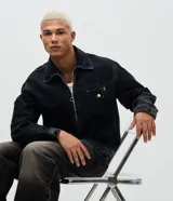 Chaqueta de jeans color negro con lavado desgastado, corte boxy, cuello camisero, cierre frontal con cremallera metálica y bolsillo frontal con cierre y solapa. Marca Blue Steel.