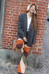 Pantalón acampanado de pana color beige con parches de pana marrón, verde y naranja.