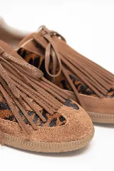Championes urbanos con diseño original de cuero en tono suela y detalles de pelo con estampado animal print. Presenta flecos decorativos en la capellada sobre los cordones y suela de goma.