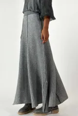 Pollera larga tejida de lana, color gris con rayas verticales en un tono más claro. Tiene cintura elástica y corte acampanado.