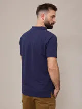 Chomba azul marino de piqué de algodón con cuello clásico y tapeta de dos botones. Logo bordado en el pecho. Corte clásico.