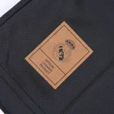 Remera de fútbol negra con cuello redondo y mangas cortas, con el escudo del Real Madrid estampado en el pecho y detalles en azul en los hombros.