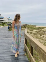 Vestido largo estampado con diseño paisley en tonos azules, verdes y rosados. Presenta un escote halter y un corte holgado que cae hasta el tobillo.