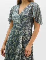 Vestido largo de fiesta con diseño cruzado, escote en V y drapeado lateral en la cintura. Presenta mangas cortas acampanadas y falda amplia con caída fluida. Confeccionado en tejido liviano con acabado plisado y estampado floral metalizado.