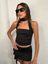 Top negro con cuello halter y espalda descubierta, confeccionado en microfibra.