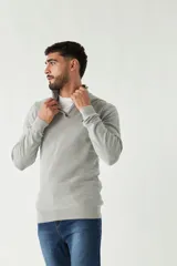 Sweater azul marino de punto con cuello alto y medio cierre con cremallera. Tiene mangas largas y logo bordado en el pecho. Corte regular.