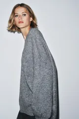 Jersey oversize color beige melange, confeccionado con lana, con cuello en V y manga larga.