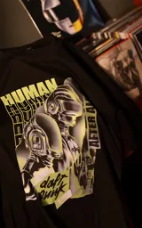 Remera de algodón premium con calce oversize, cuello redondo y mangas cortas. Presenta un estampado frontal gráfico con temática de Daft Punk en tonos verdes y violetas sobre fondo negro.