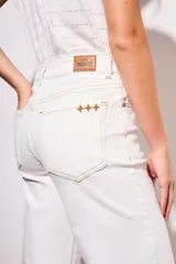 Pantalón de jean blanco, de corte wide leg y tiro medio, con terminación desflecada.