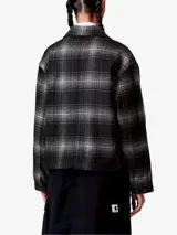 Camisa tipo jacket de Carhartt WIP con diseño a cuadros, confeccionada en mezcla de lana. Presenta corte boxy, cierre frontal con botones, cuello clásico y bolsillo en el pecho con parche de la marca.