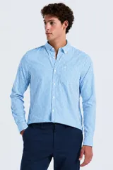 Camisa de manga larga con estampado de cuadros Gingham en tonos celeste y blanco, cuello abotonado y cierre frontal con botones.