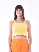 Musculosa amarilla de punto acanalado, corta, con tirantes anchos y un pequeño bordado de mariposa en el centro del pecho.
