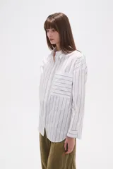 Camisa de algodón con diseño de rayas verticales, corte holgado, cuello camisero, cierre frontal con botones, mangas largas con puños y un bolsillo frontal con rayas horizontales.