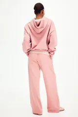 Jogging rosado de felpa con cintura elástica y cordón ajustable, de corte holgado y piernas amplias con bolsillos laterales.