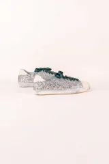 Zapatillas urbanas plateadas con glitter, puntera y talón en cuero blanco, cordones de raso verde esmeralda y suela blanca.