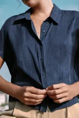 Camisa fluida oversize de lyocell color azul marino, con cuello solapa, manga corta tipo murciélago y cierre frontal con botones.