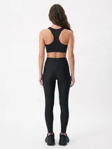 Top deportivo negro con diseño de espalda deportiva y escote redondo.