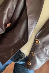 Campera bomber de cuero color vino, con cuello de piel sintética desmontable y corte oversized.
