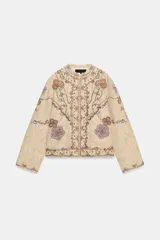 Chaqueta de hilatura de algodón en color beige, de cuello redondo y manga larga, con aplicaciones de bordados a contraste.
