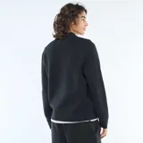 Cardigan de punto color negro con cuello alto y cierre frontal completo. Presenta puños y ruedo acanalados.