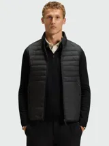 Chaleco acolchado de diseño técnico, con cierre frontal completo y cuello alto. Presenta un acabado liso y minimalista, ideal para capas intermedias o exteriores.