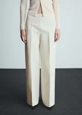 Pantalon de vestir tipo wide leg, color crema, con tiro medio, pinzas frontales y cierre lateral invisible.