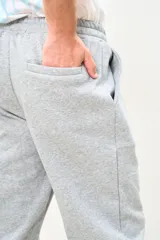 Pantalón de jogging gris melange, con cintura elástica ajustable con cordón, bolsillos laterales y puños ajustados en los tobillos.