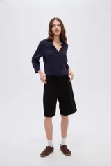 Short ancho de poliéster color negro, de tiro alto y diseño sastrero con pinzas en el frente.