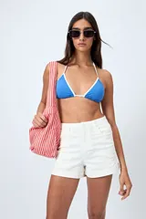 Short blanco de algodón con elastano, calce medio, bolsillos funcionales y tajos pequeños en el ruedo.