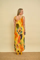 Vestido largo de gasa de seda con estampado floral en tonos amarillos, naranjas y verdes, sin mangas y corte al bies con caída fluida.