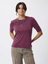 Remera de cuello redondo y manga corta, confeccionada en tejido de viscosa y poliéster, con un diseño básico y versátil.
