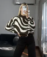 Sweater de tejido de punto con diseño de ondas en color marrón y crema, de cuello redondo y manga larga.
