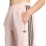 Pantalón deportivo Adidas de corte holgado y pernera ancha, en color rosado con bandas laterales oscuras y el clásico logo del trébol bordado. Cuenta con cintura elástica y bolsillos laterales.