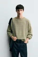 Jersey relaxed fit de punto ligero color verde claro, con rayas horizontales en un tono más claro. Tiene cuello redondo amplio, manga larga y acabados en rib.