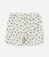 Bermuda de baño para hombre, color crema, con estampado repetitivo de peces azules. Presenta cintura elástica con cordón de ajuste y forro interior de malla.