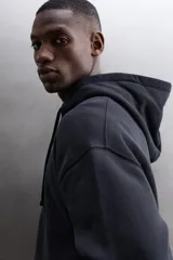 Sudadera con capucha y cierre de cremallera de doble dirección, color negro, de corte relaxed fit, con bolsillos frontales tipo canguro y puños y bajo elásticos.