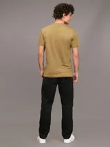 Remera color ocre de algodón con cuello redondo y mangas cortas. Cinta con logo en espiguilla de Calvin Klein en los laterales.