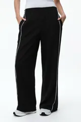 Pantalón de corte recto con cintura elástica y detalle de ribetes laterales en contraste. Confeccionado en tejido de algodón con elastano para mayor comodidad.