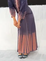 Falda larga de algodón color lavanda con teñido degradado en tonos rosados. Corte a la cintura con dos bolsillos laterales y cierre invisible.